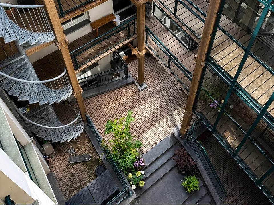 Binnenplaats met trappen en galerijen van een appartementencomplex