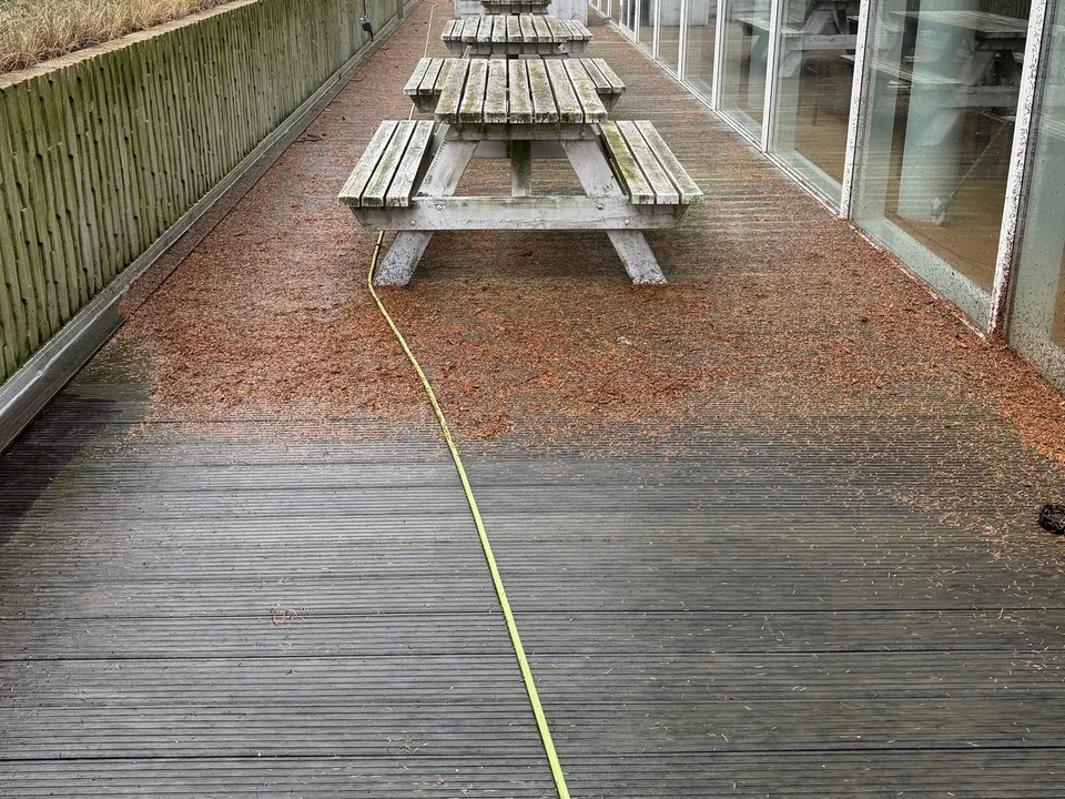 Houten terras met picknicktafels wordt gereinigd