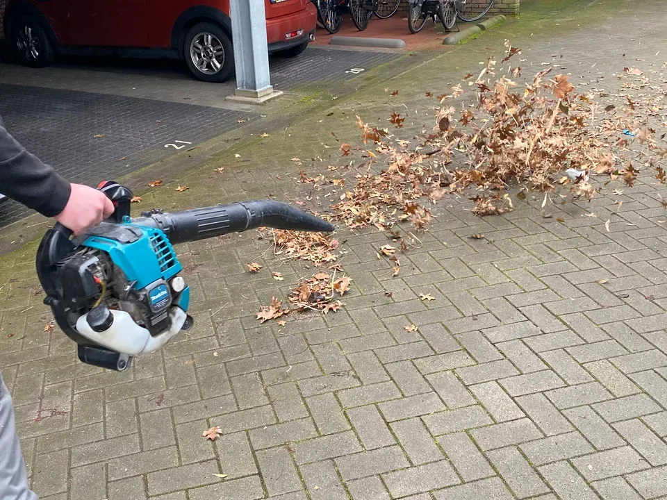 Bladblazer ruimt bladeren van de bestrating