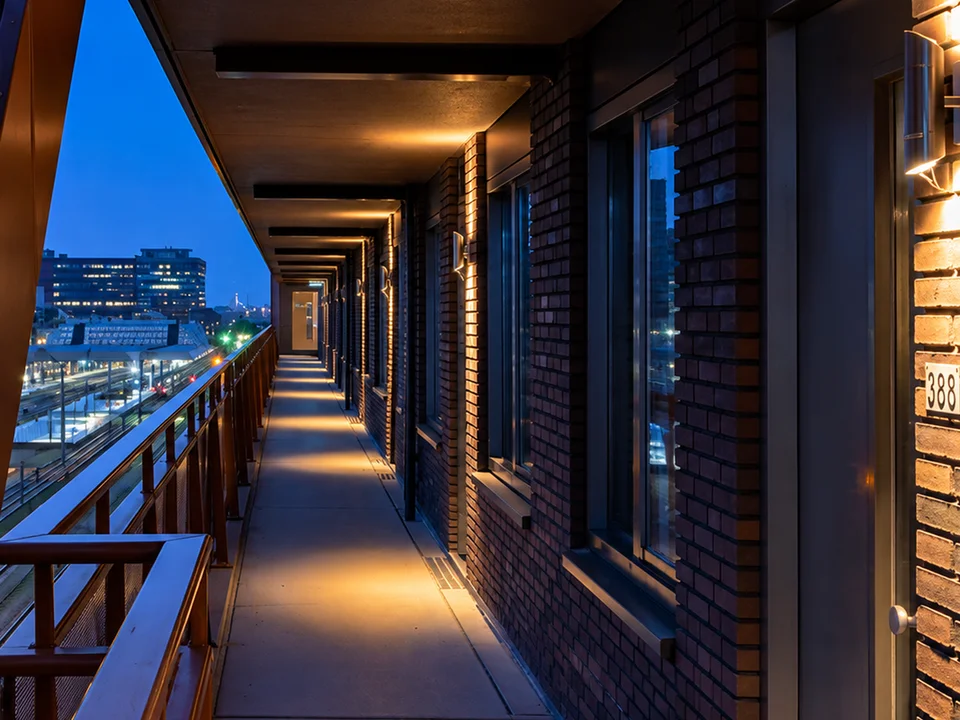 Verlichte galerij van een appartementencomplex in de avond